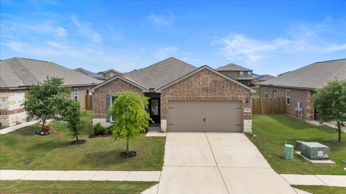 View of front of home with brick siding, an attac