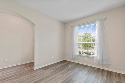 Empty room featuring arched walkways and light wo