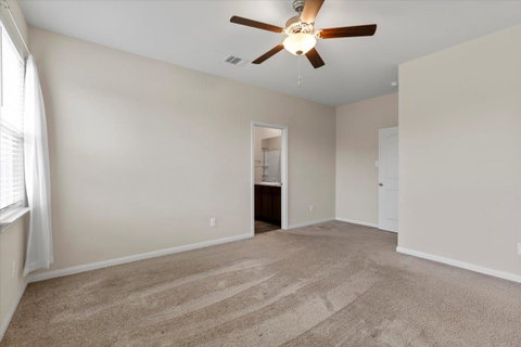Unfurnished bedroom with a ceiling fan, light car