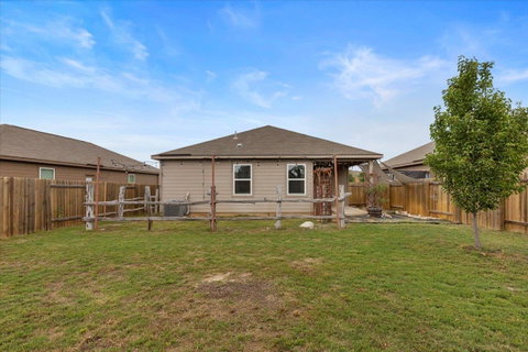 Rear view of property with a patio area and a fen