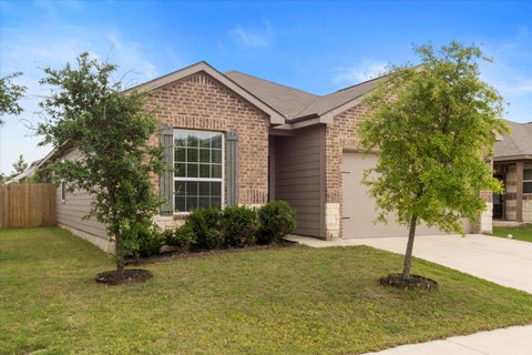 View of front of property with brick siding, a ga