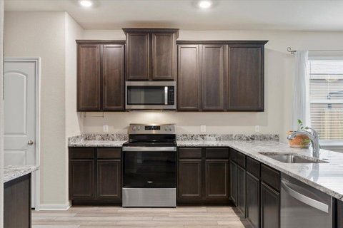 Kitchen with stainless steel appliances, dark woo