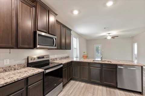 Kitchen with stainless steel appliances, dark woo