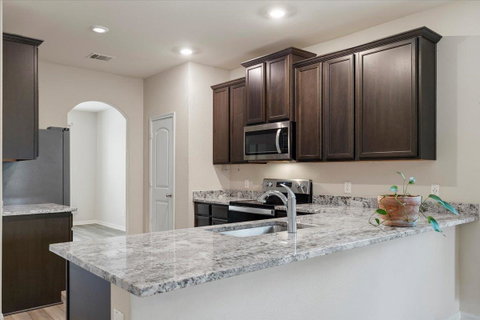 Kitchen featuring dark wood finish cabinets, arch