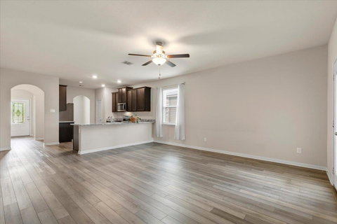 Unfurnished living room featuring a ceiling fan, 
