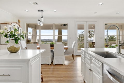 Kitchen with light stone counters, light wood fin