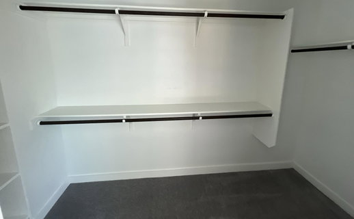 Walk in closet featuring dark carpet
