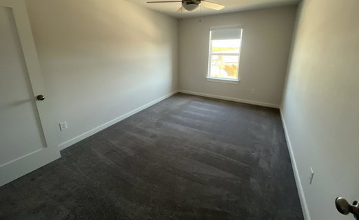 Spare room with dark carpet and ceiling fan
