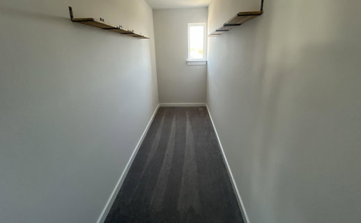 Corridor featuring baseboards and dark colored ca