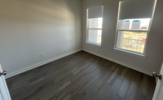 Unfurnished room with baseboards and dark wood fi
