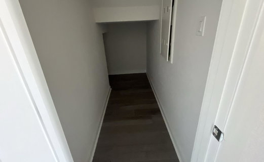 Hallway featuring baseboards and dark wood-style