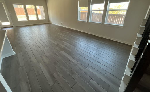 Unfurnished living room with dark wood-style floo